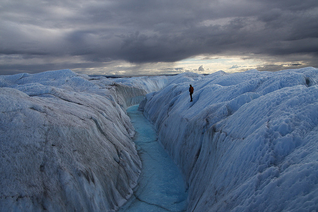 A supraglacial meltwater stream cuts a canyon through the surface of the Greenland ice sheet